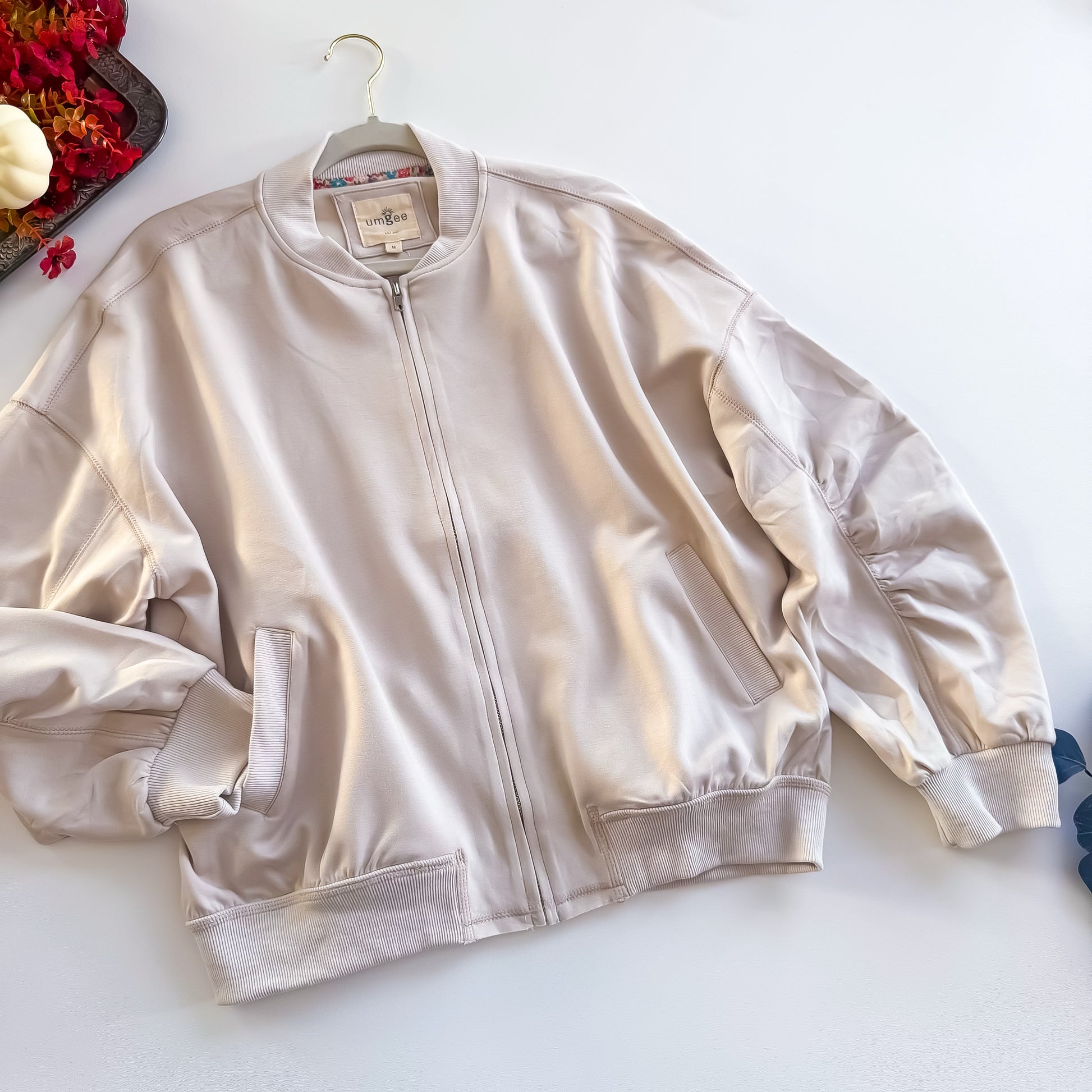 Cream zip-up bomber jacket flat lay