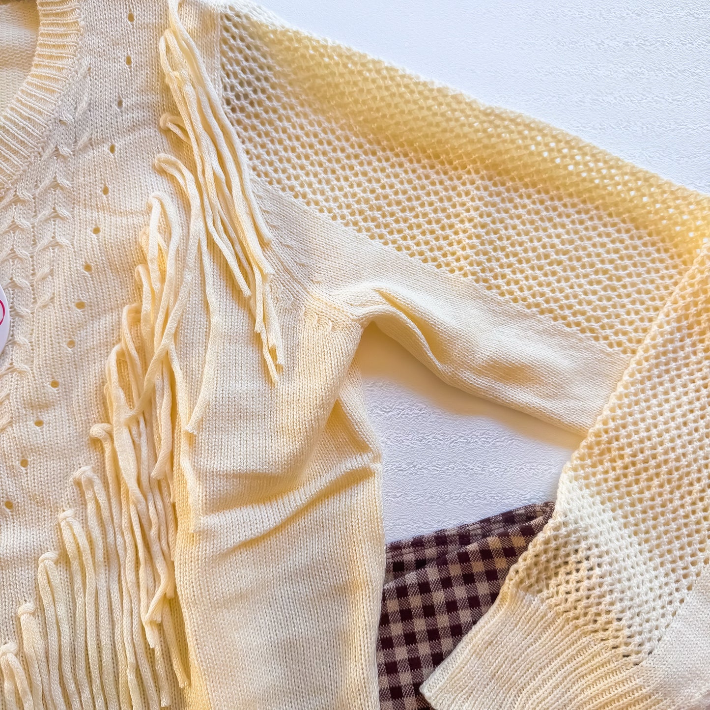 Cream fringe sweater sleeve detail