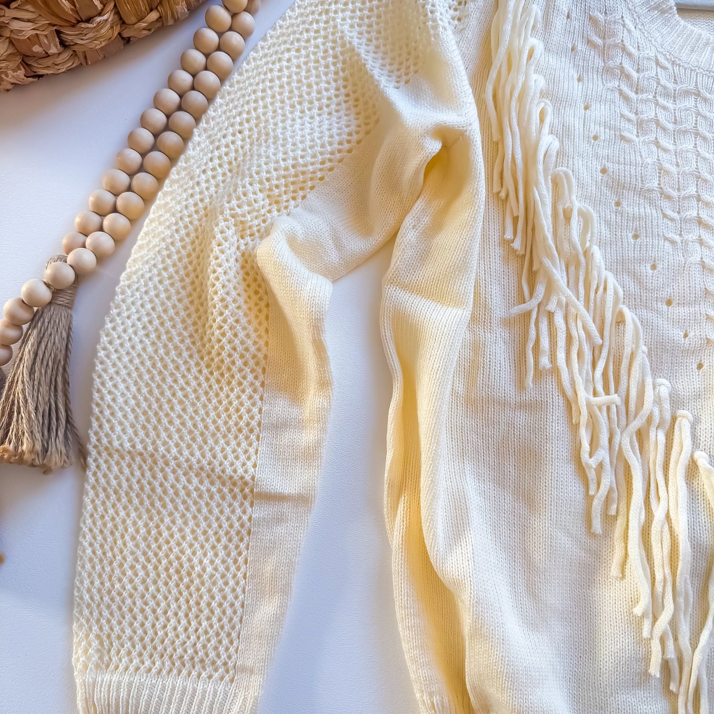 Cream fringe sweater knit and fringe detail