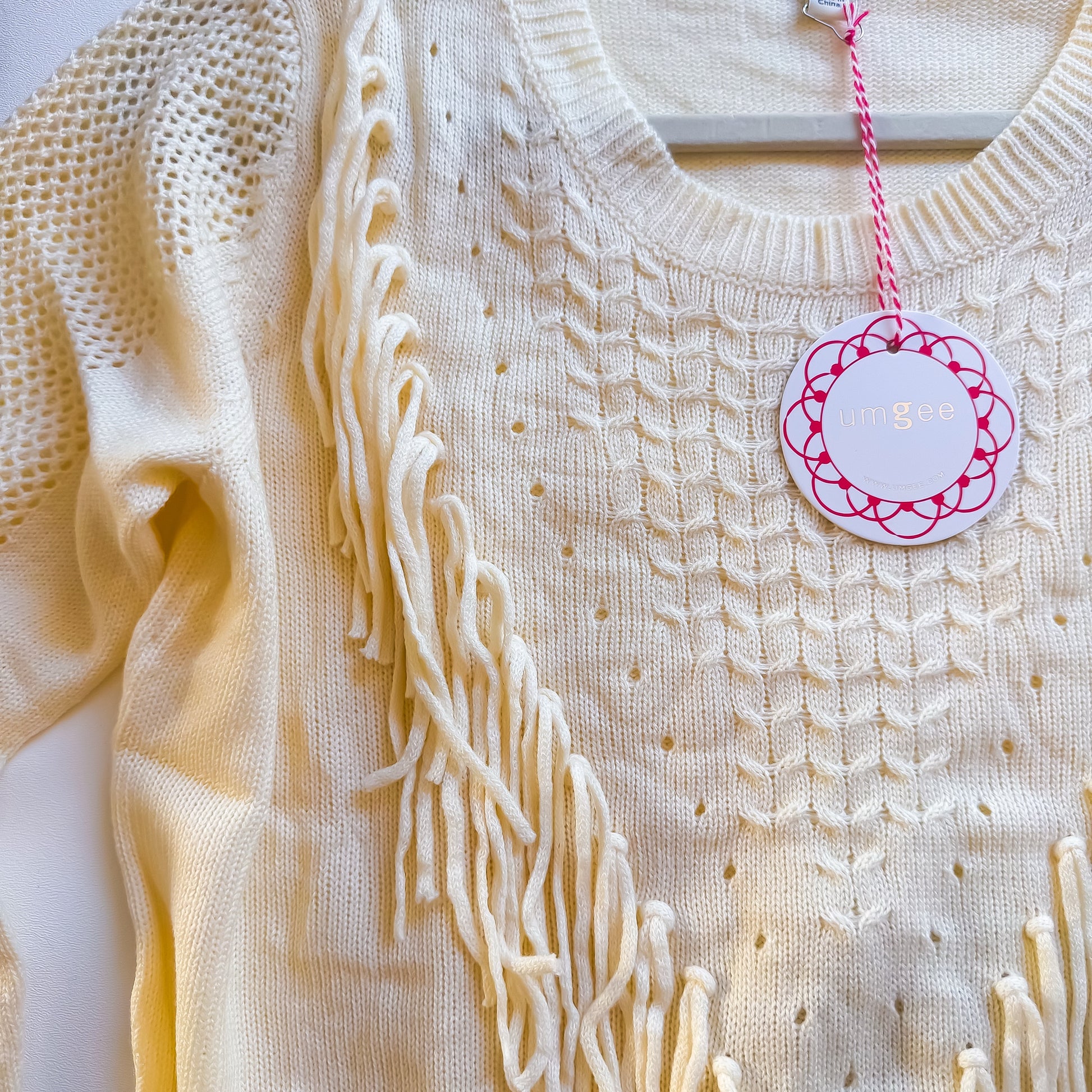 Cream fringe sweater neckline detail