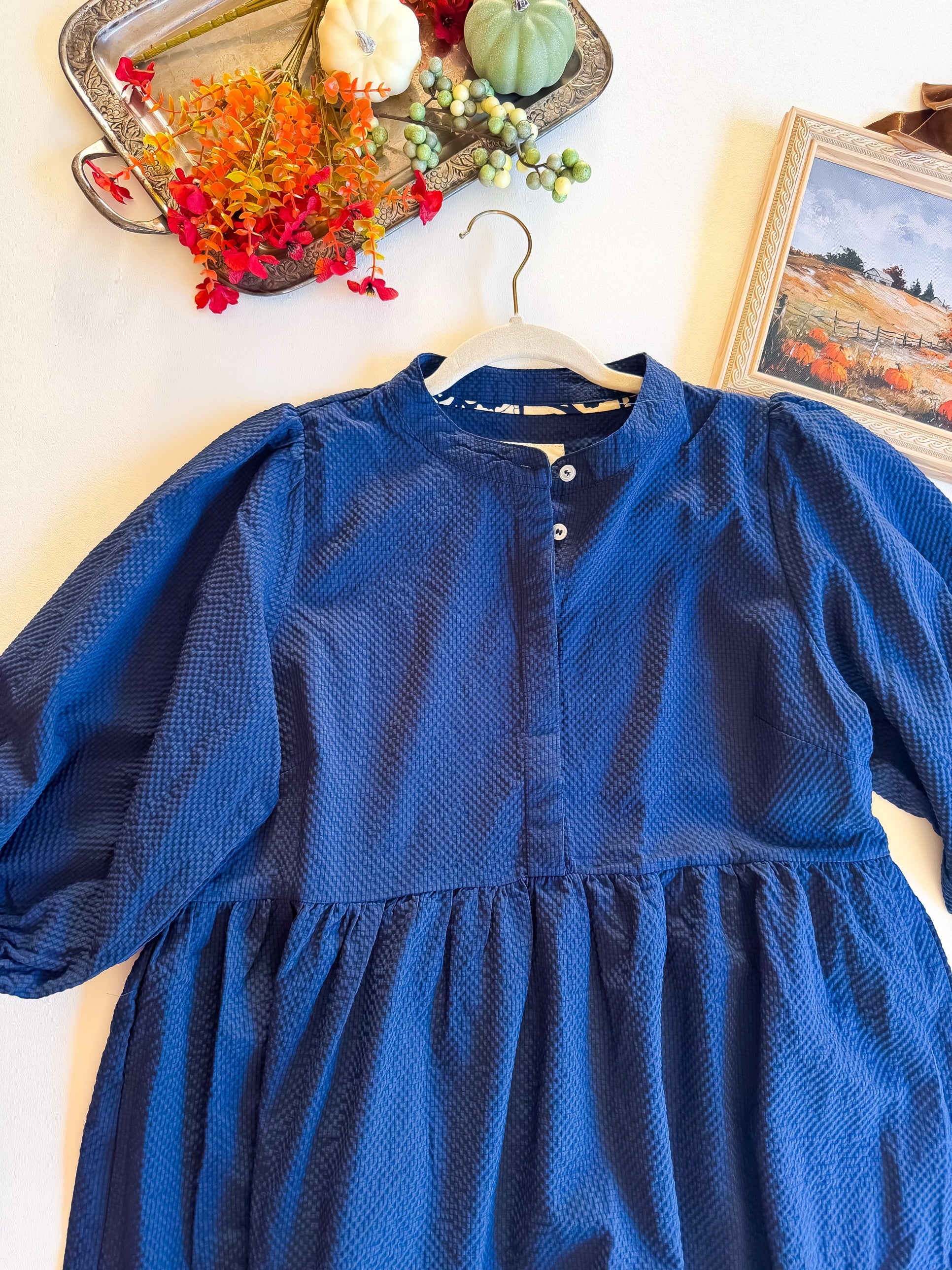 Close-up of navy Umgee dress bodice, puff sleeves and gathered tier