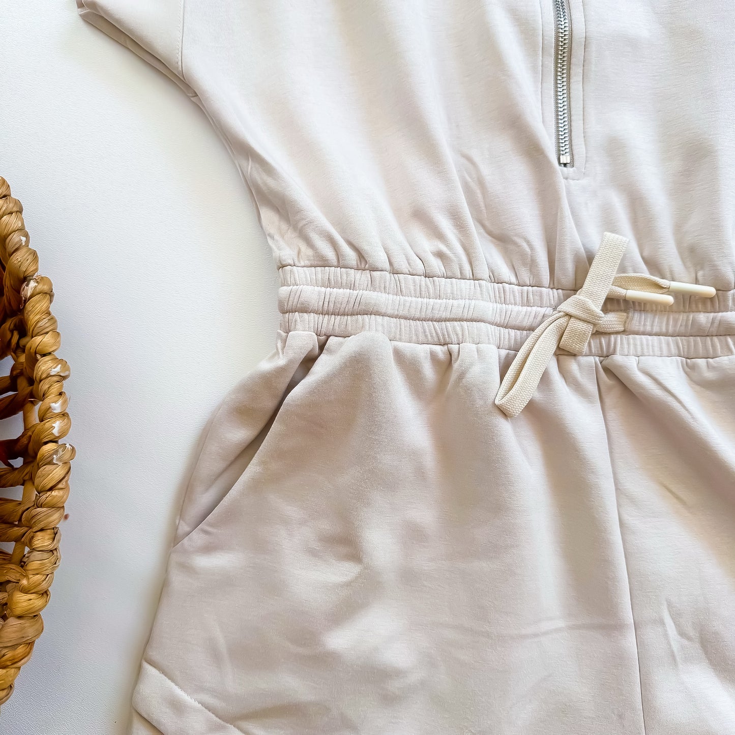 Cream romper waist and pocket detail