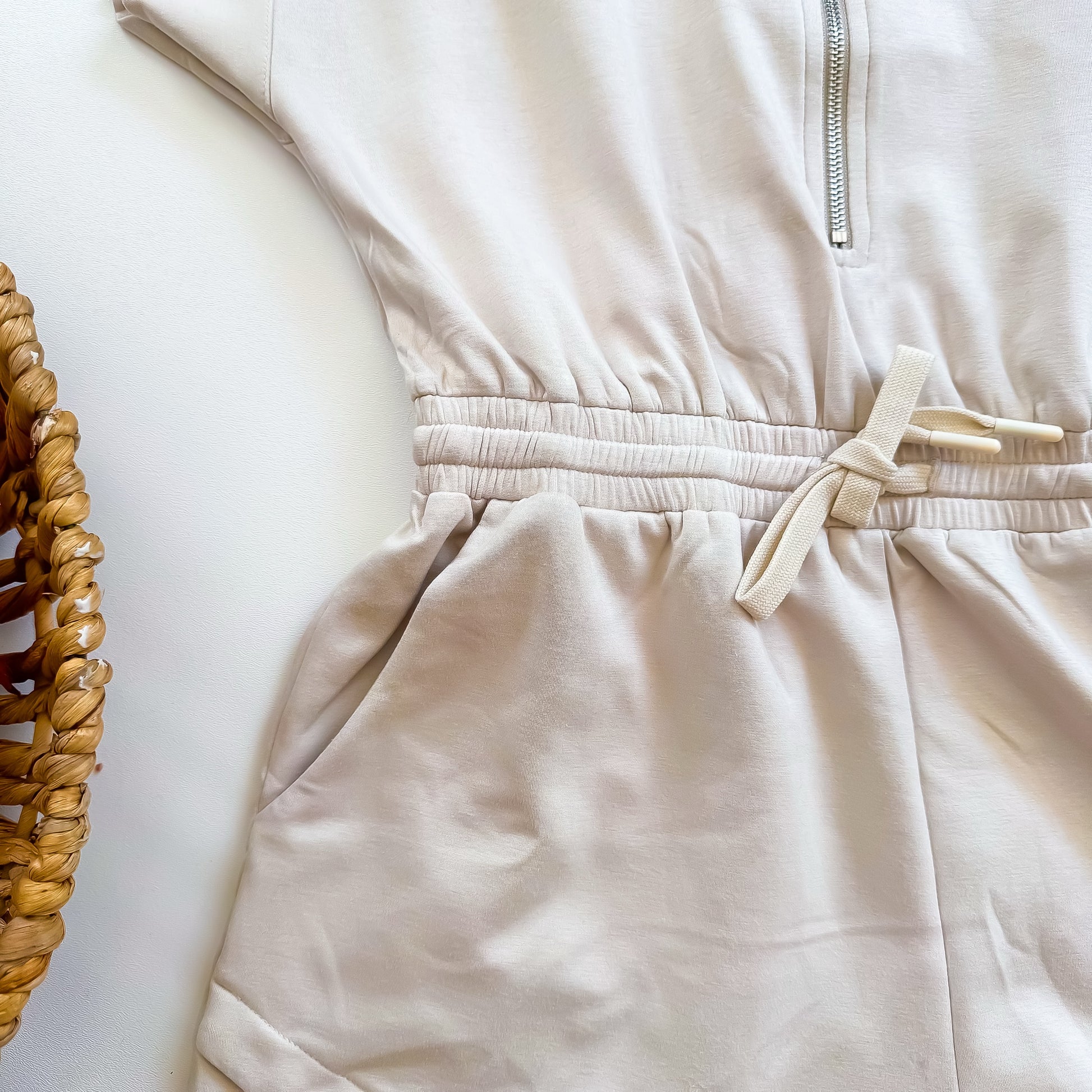 Cream romper waist and pocket detail