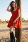 Red smocked sweetheart flutter sleeve tiered mini dress on model